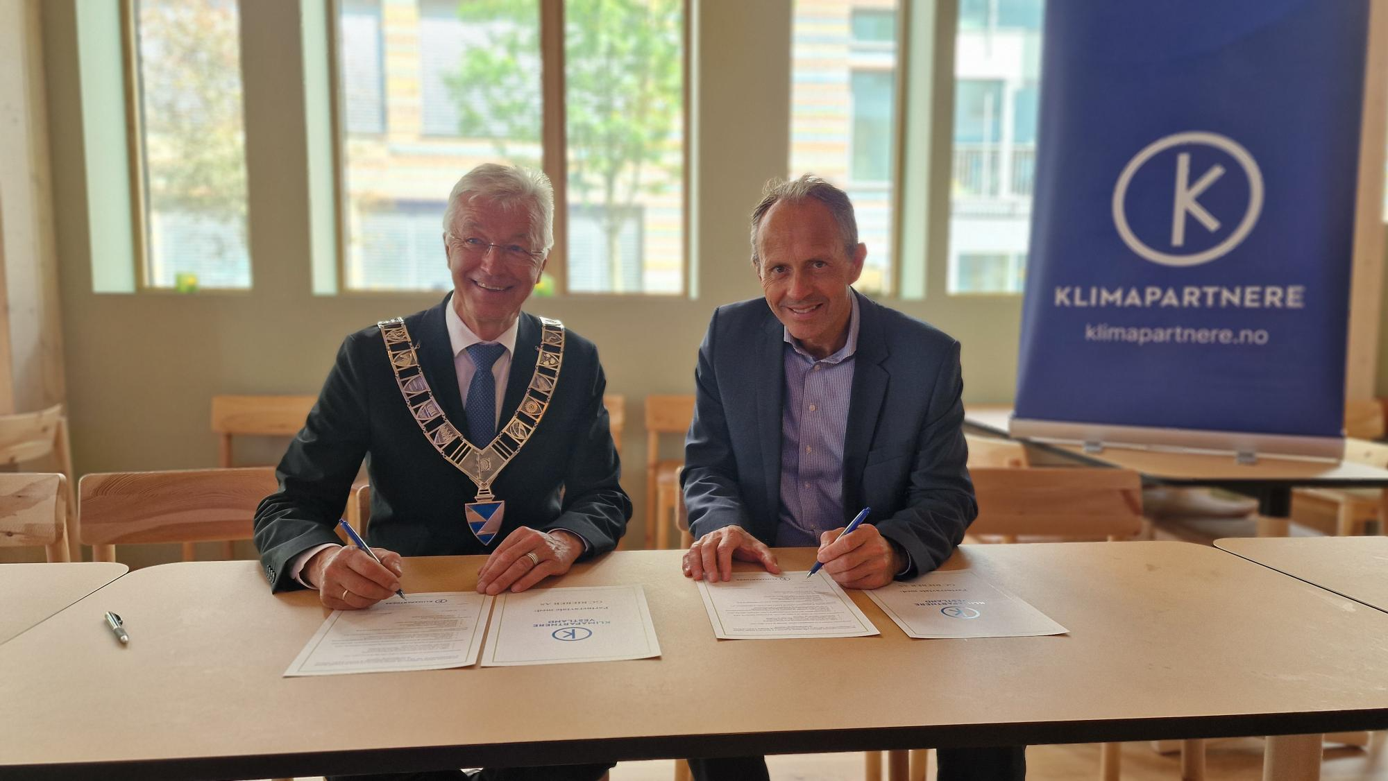 Bilde av fylkesordfører Jon Askeland og GC Riebers CEO Jan Roger Bjerkestrand som signerer Klimapartnere Vestland-avtalen.
