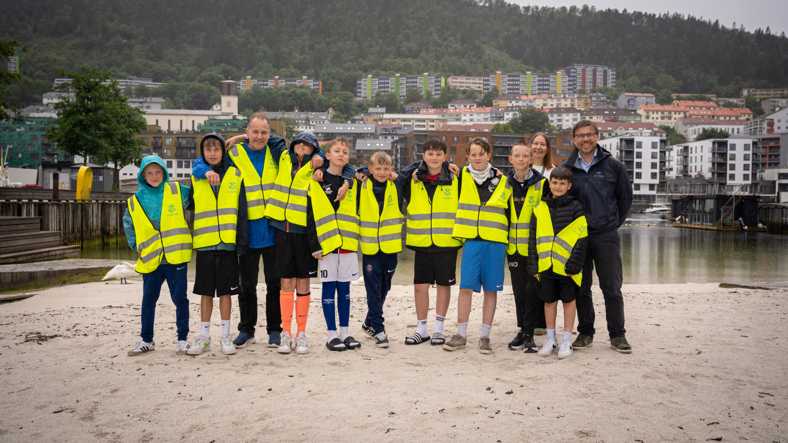 Bilde på Bystranden på Marineholmen av ungdommer fra SK Djerv sammen med styreleder Espen Edvardsen (SK Djerv), Henriette Indrøy Hansen (leder for drift) og Øyvind Ramberg (direktør for marked og forretningsutvikling) fra GC Rieber Eiendom.